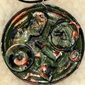 Artistic pendant with a green and black design.